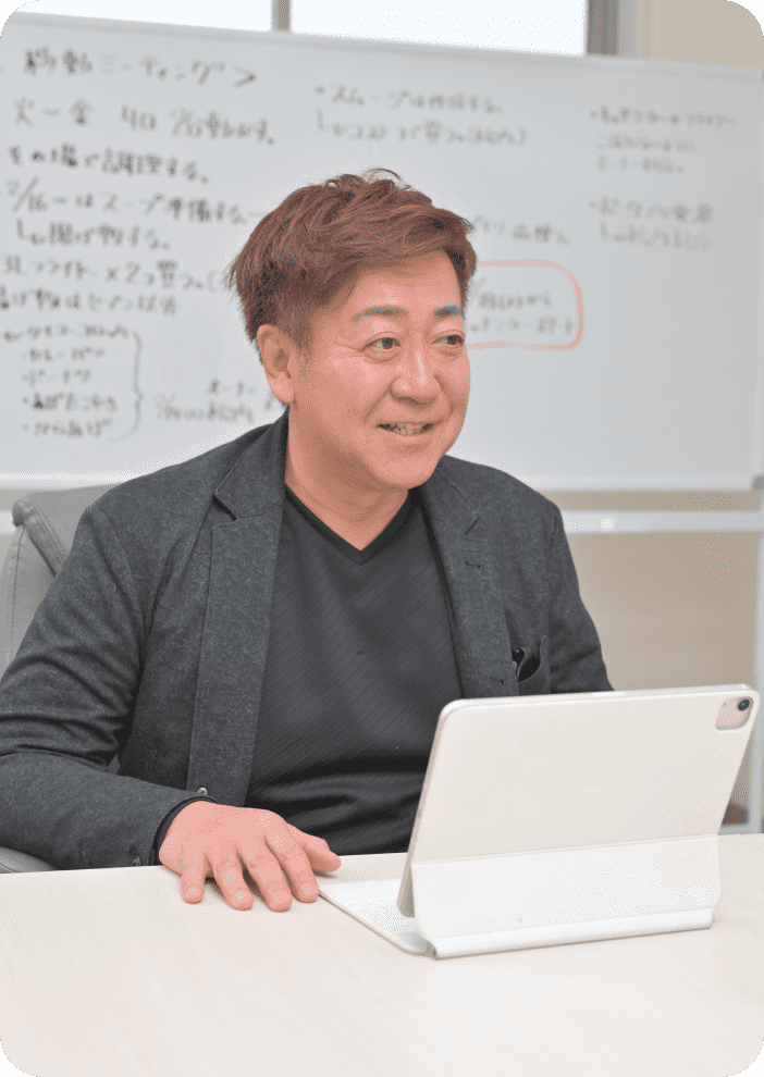 代表取締役 鯨井 祐介の写真。黒い髪の男性が、正面を向いて笑顔で写っている。